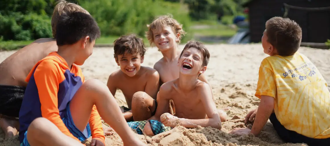 Male campers enjoying playtime on the beach at SLC