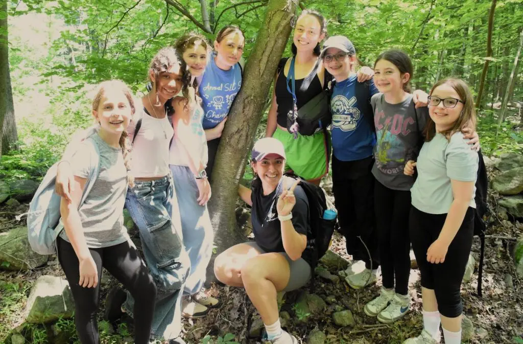 Young campers posing in front of a tree.