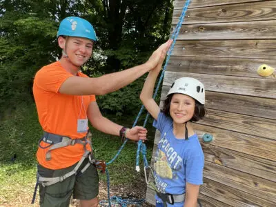 Climbing staff member with camper