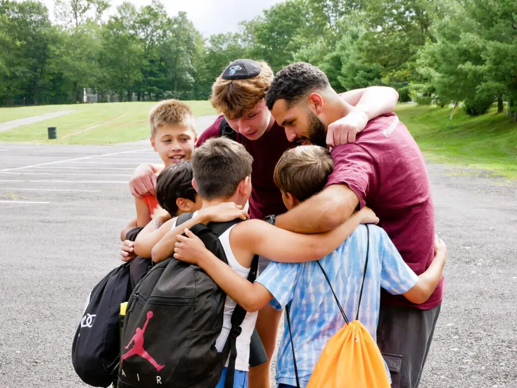 Campers and staff hugging at camp.